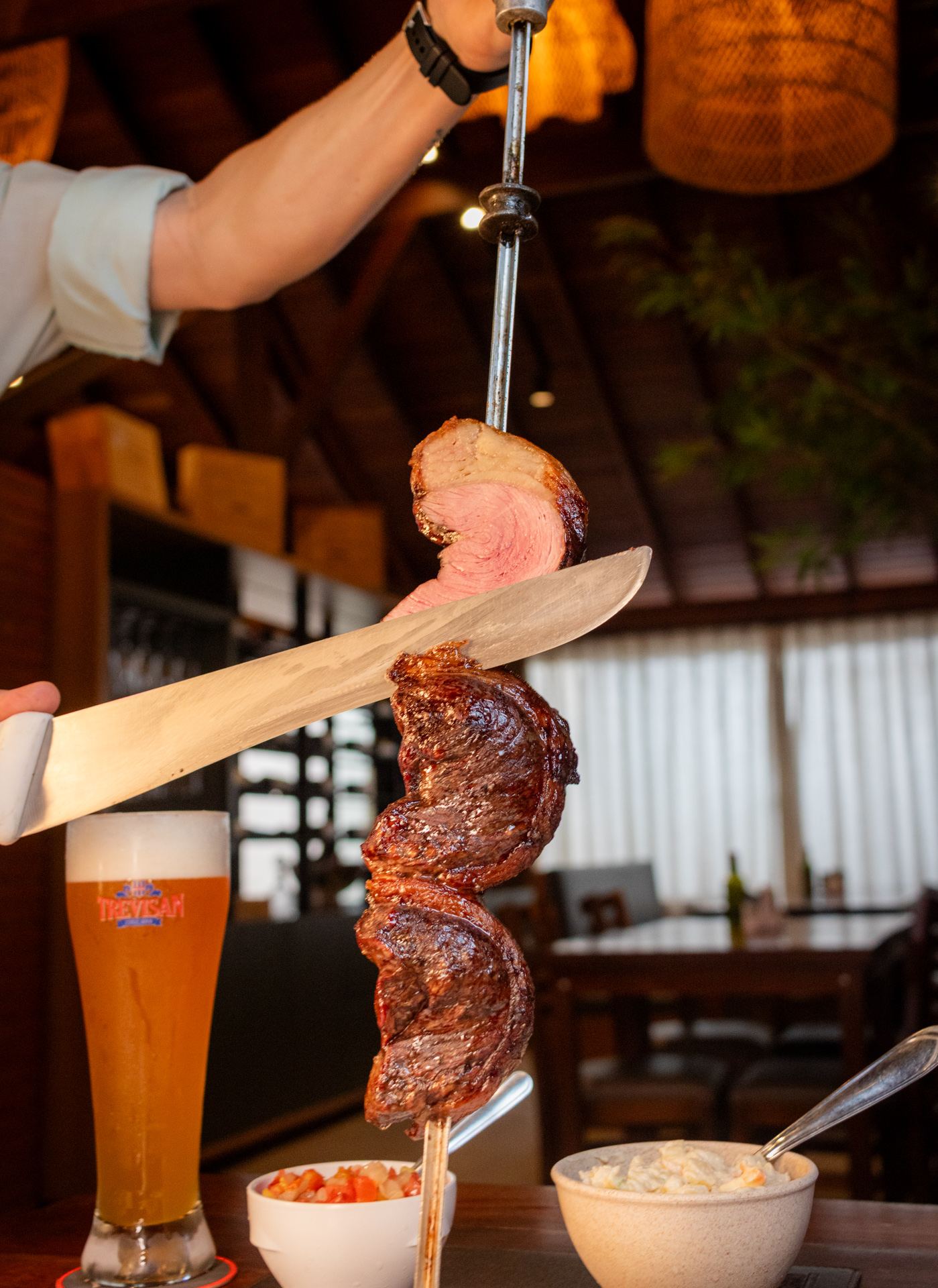 Picanha sendo cortada no espeto no Braseiro Gaúcho, restaurante e churrasco em Penedo